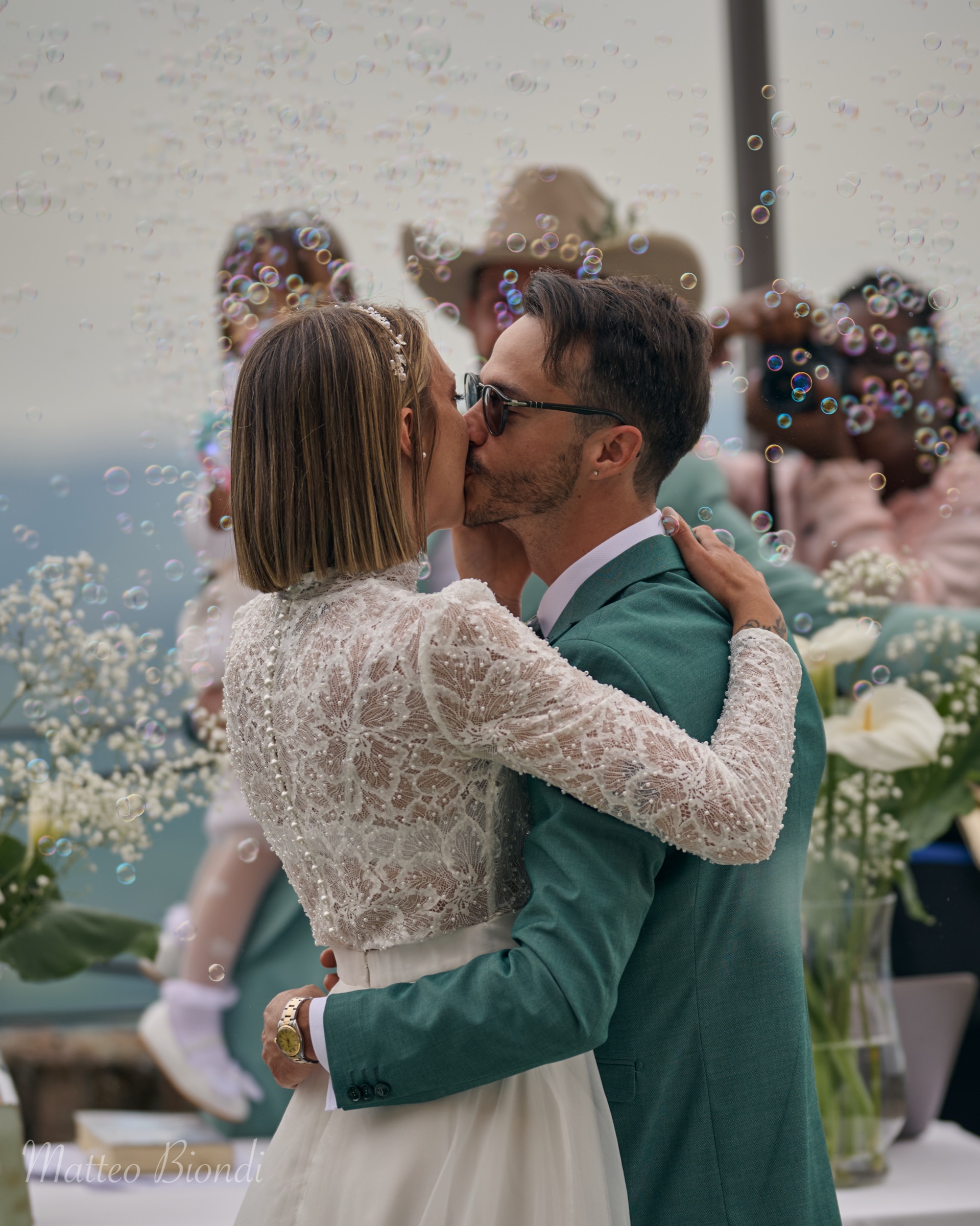 Bacio degli sposi circondati dalle bolle di sapone