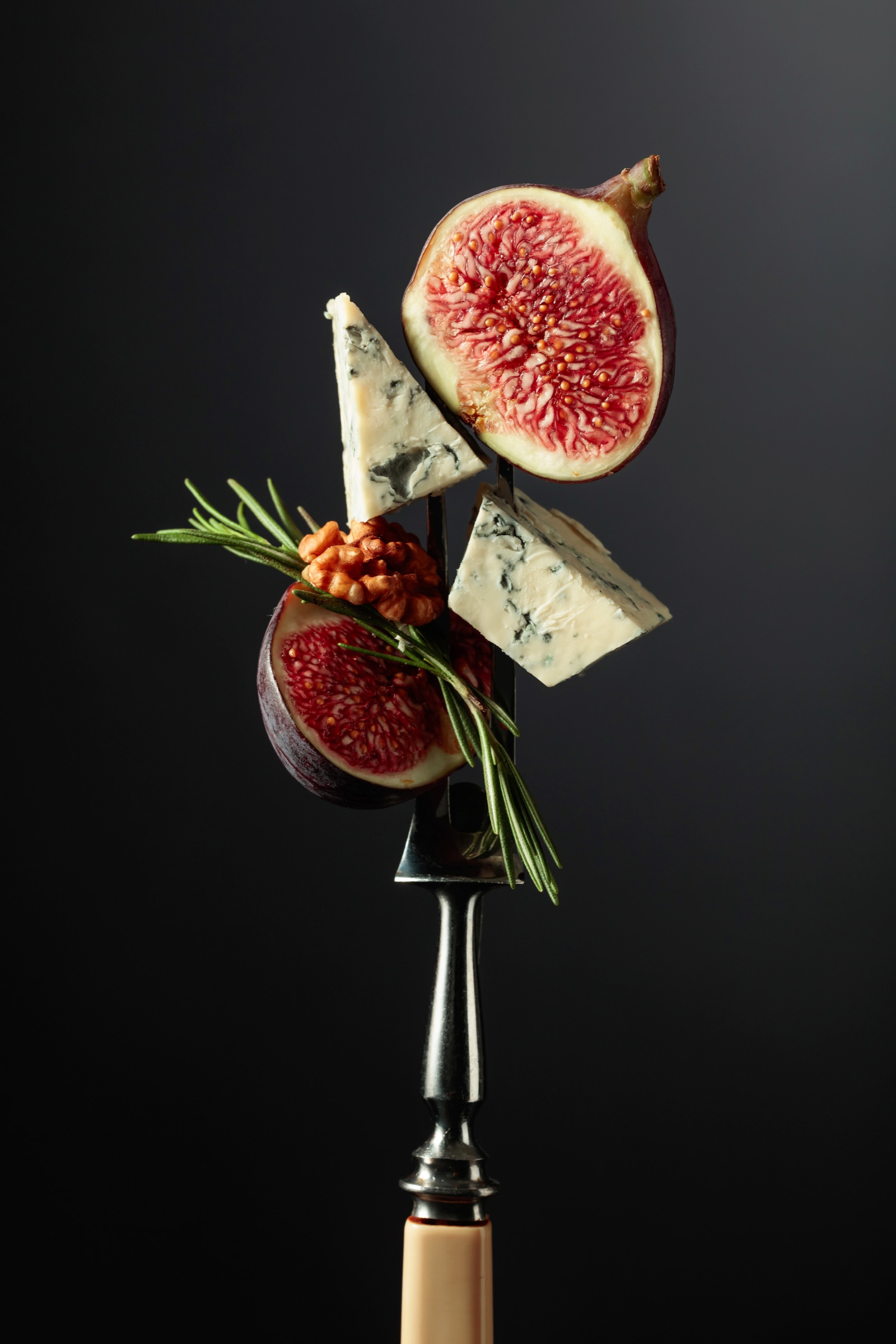 Still life gastronomico con fichi, formaggio erborinato, noci e rosmarino